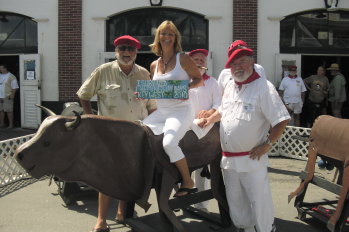 Terri Jamison on a bull with prior Papa Hemingway contest winners during the hemingway days running with the bulls